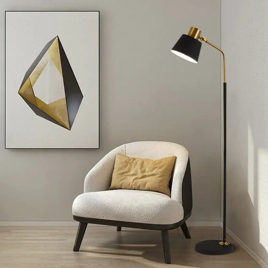 Cream-colored upholstered armchair with dark wood legs and mustard-yellow cushion beside DecorBites black floor lamp